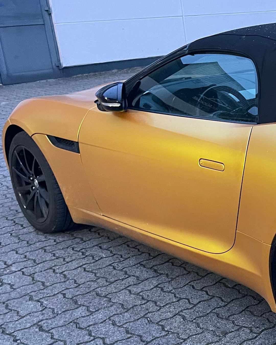 Seitenansicht der Vollfolierung in Satin Gold am Jaguar F-TYPE, Fahrertür und Kotflügel